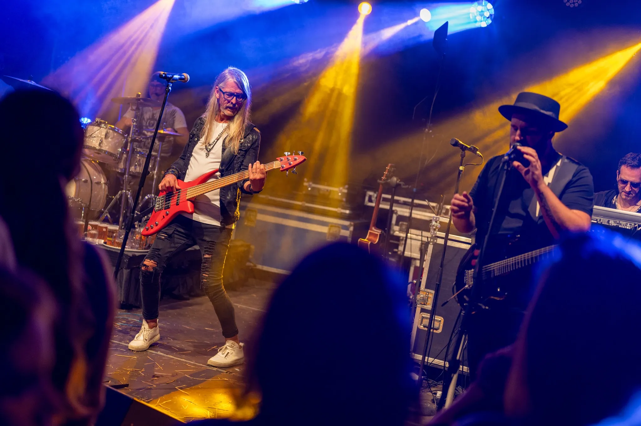 Joe Kulmesch mit E-Gitarre im gelben Scheinwerferlicht